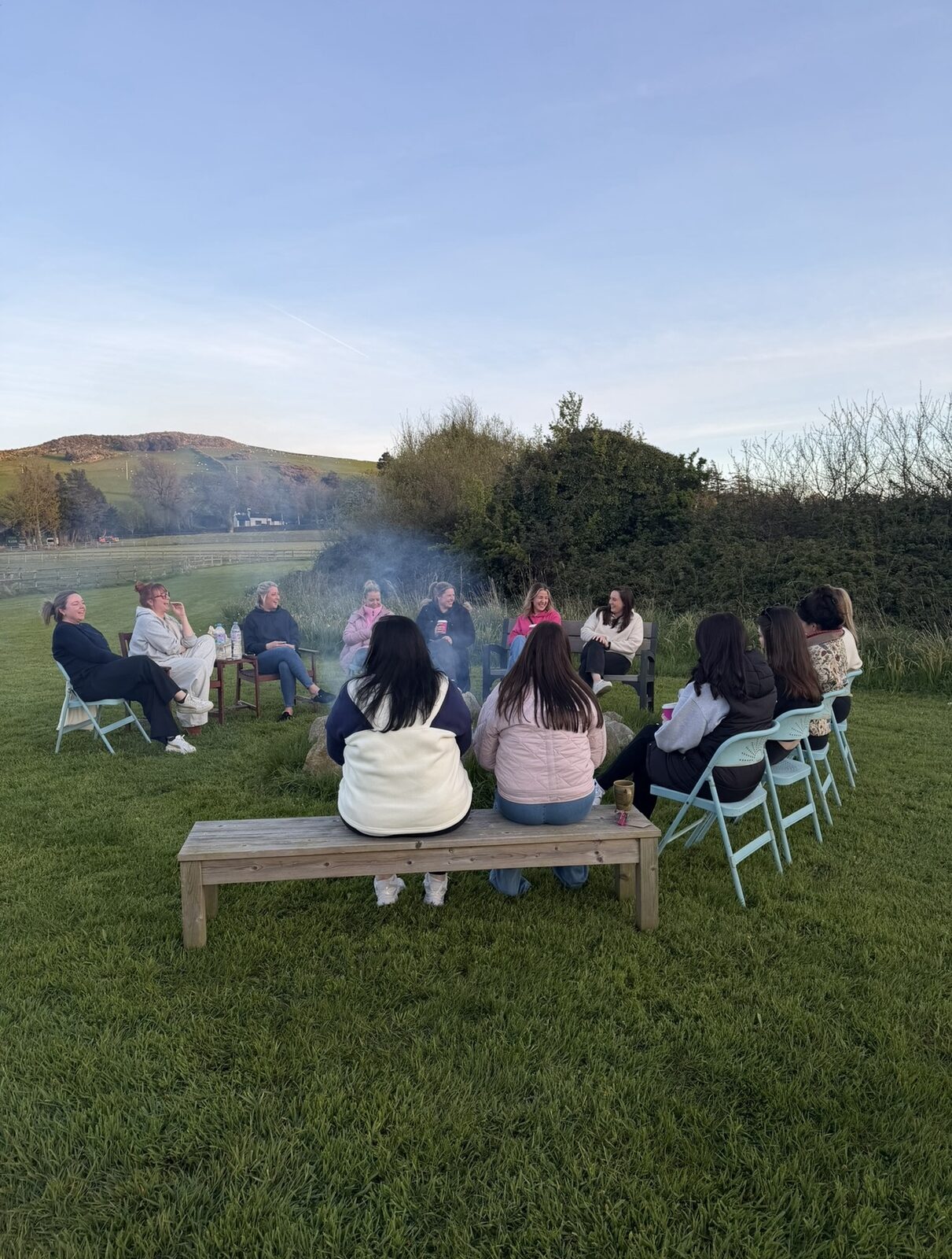 Group gathered together around a fire pit at dusk